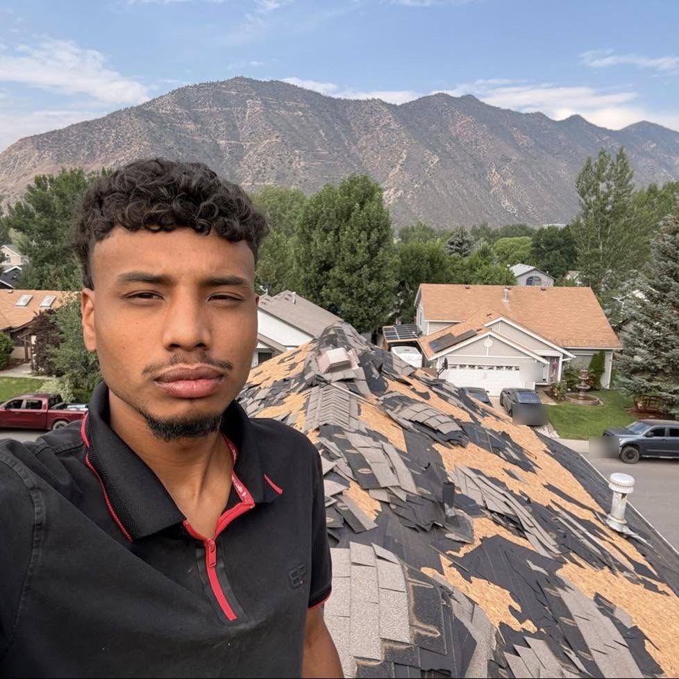 Roof tear-off in progress on a Grand Junction home with the mountains behind