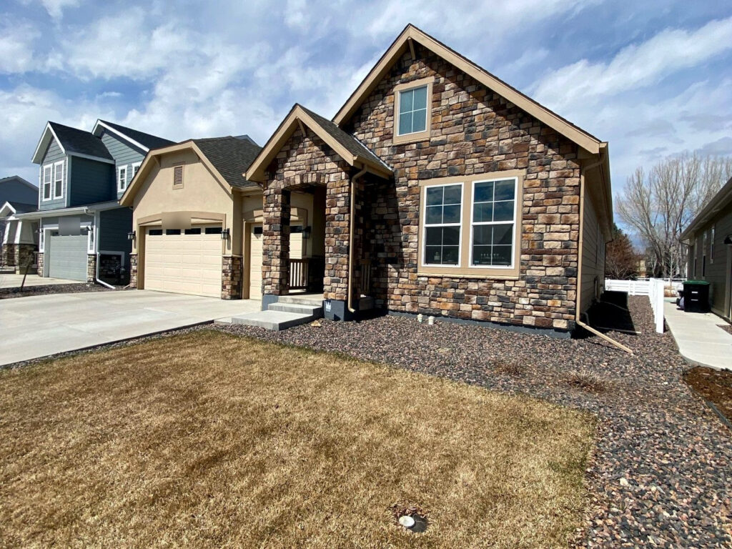 Roofing on a two-story home finished in stone and timber