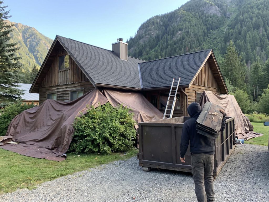 Mountain home job site with landscaping protected by tarps