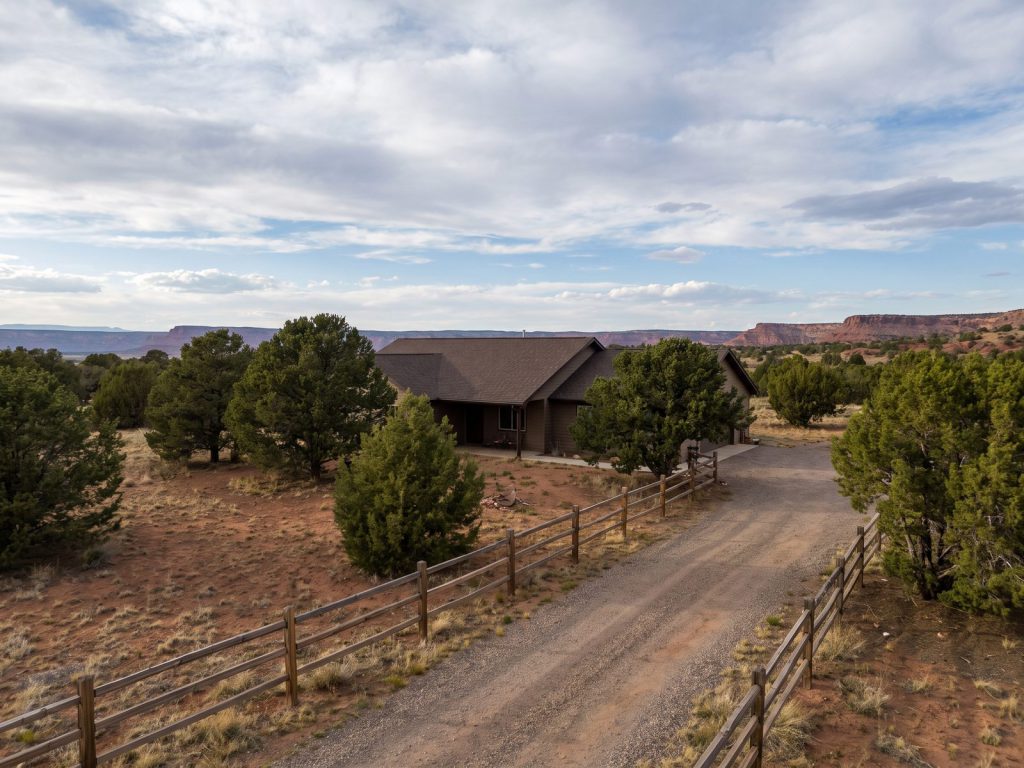 Rural high-plateau home with a new roof among piñon and juniper