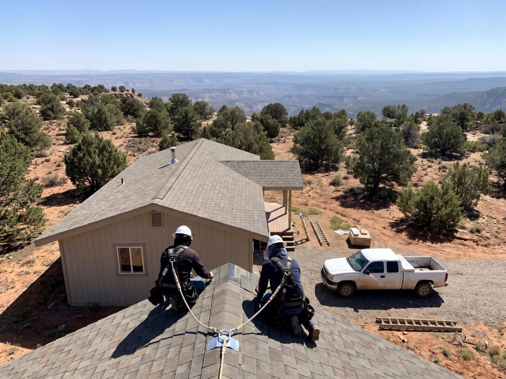 Roofers at work on a rural home high on a piñon-juniper plateau